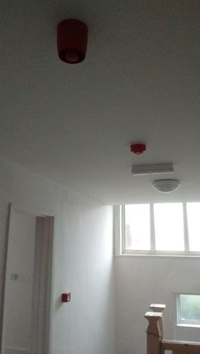 Image with fire alarm sounder, call point,  smoke detector, emergency light and communal light.